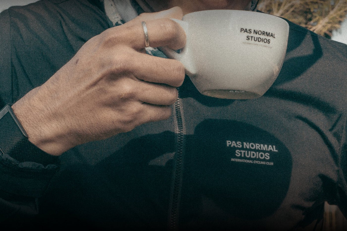 Ciclista con un café en la mano durante una pausa de la salida